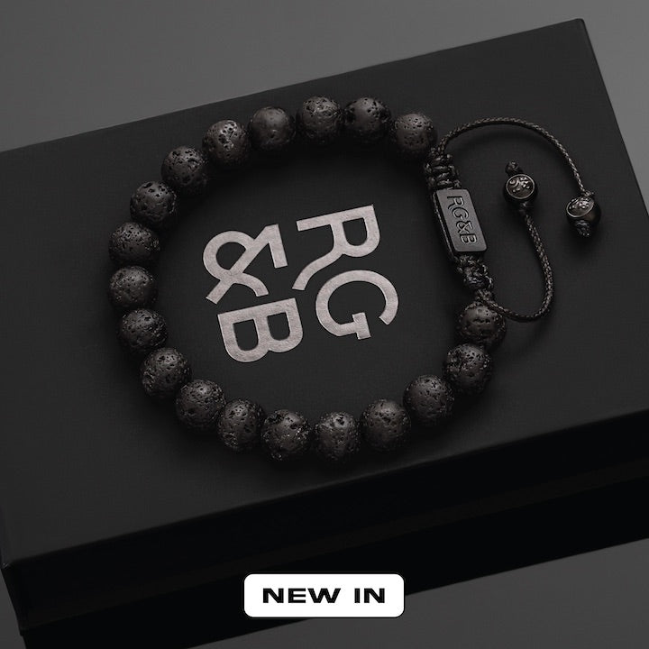 Lava Stone Bead Bracelet - Our Lava Stone Bead Bracelet Features Natural Stones, Waxed Cord and Brushed Black Steel Hardware, Engraved with the Signature RG&B Logo.